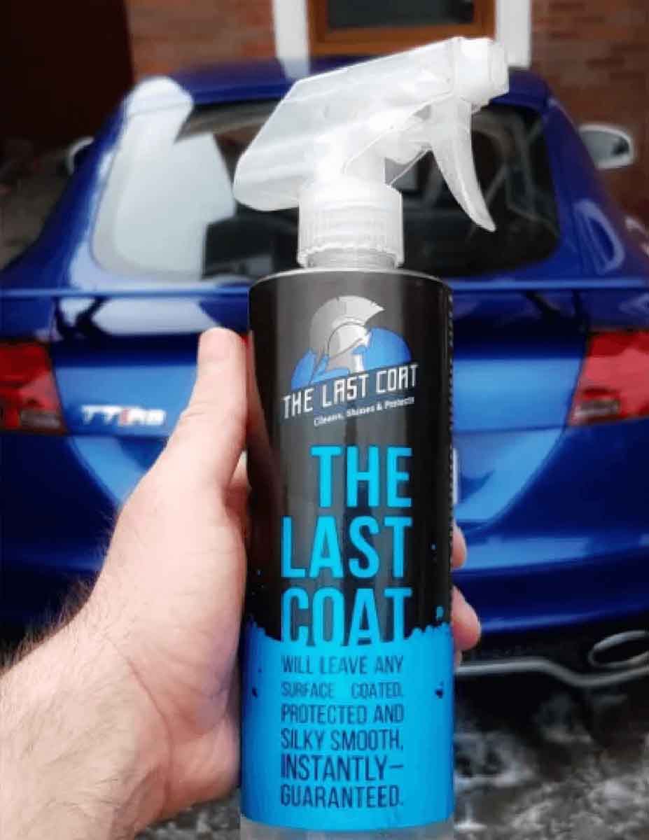 holding the last coat in front of a car