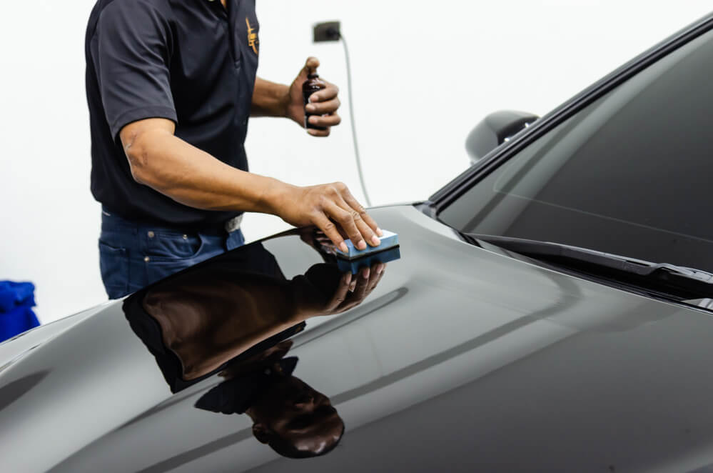 man applying ceramic coating to car