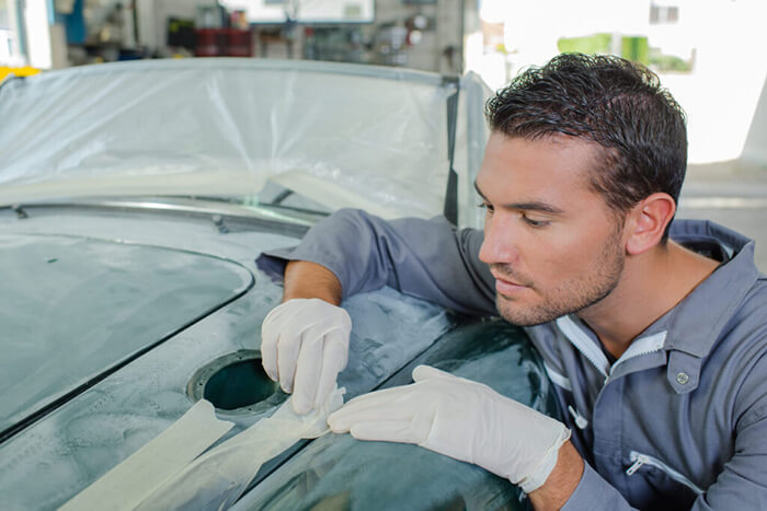 man doing car scratch repair