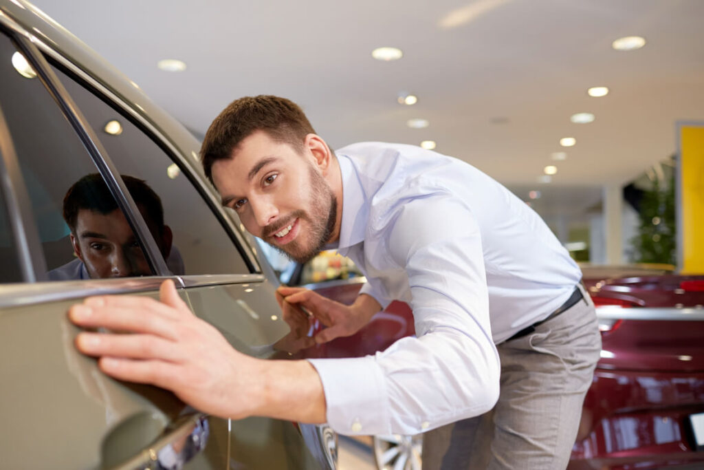  man looking at how to do touch up of car paint